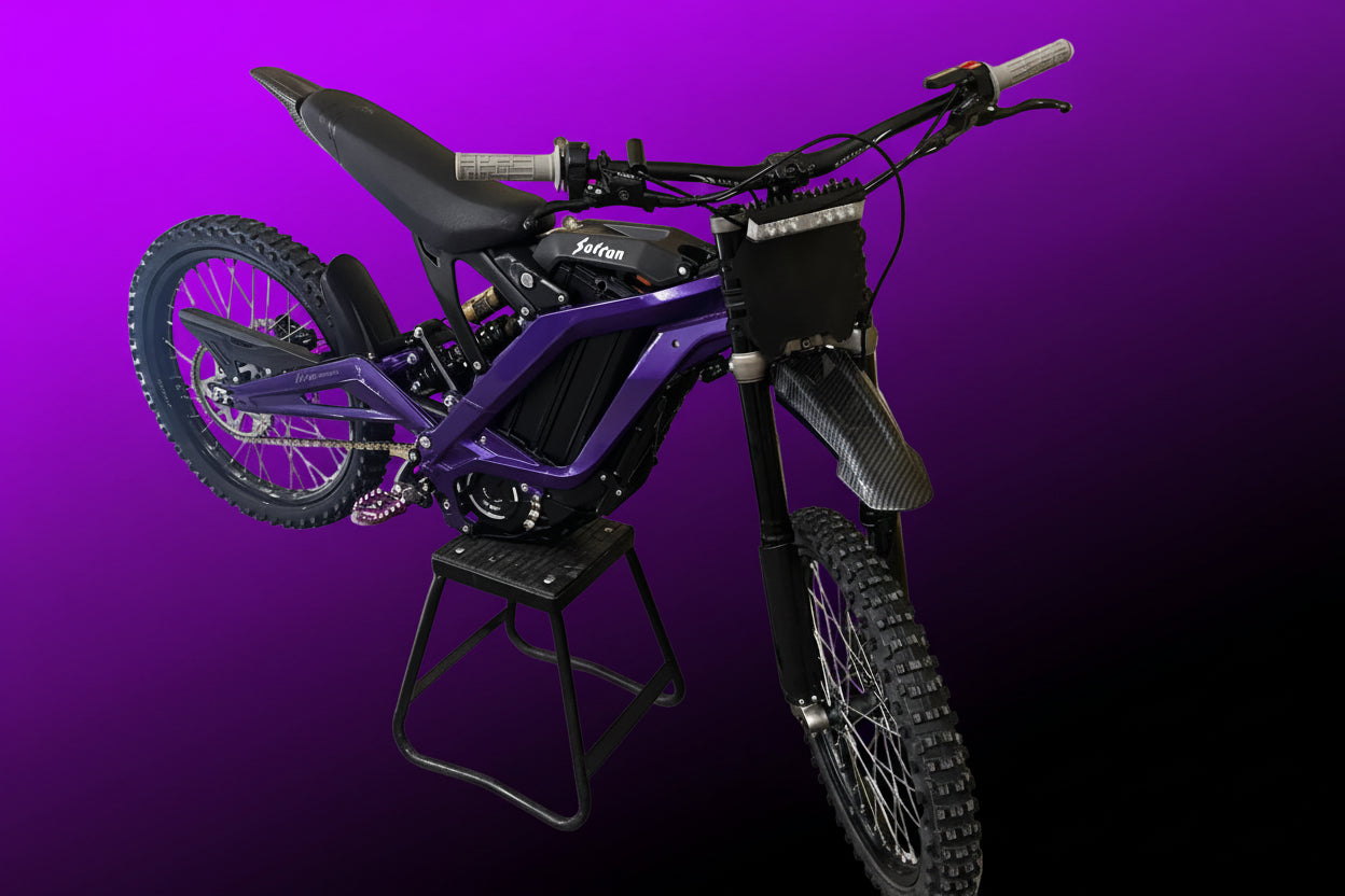 Purple dirt bike on a stand against a white background